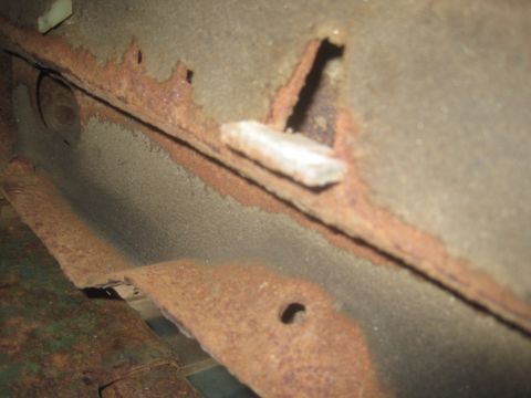 1993 Ford Bronco - Detail of significant rust and corrosion on a vehicle's undercarriage or frame component.