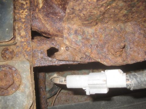 1993 Ford Bronco - Close-up of heavily rusted vehicle frame with an electrical connector visible.