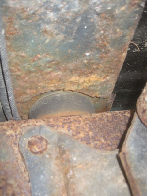 1993 Ford Bronco - Close-up of a heavily rusted suspension component, showing some stamped text.