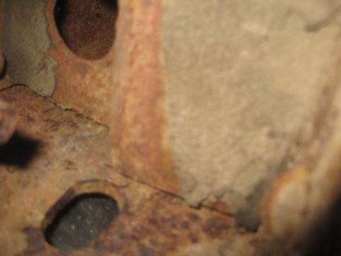 1993 Ford Bronco - Close-up of heavily rusted metal components, possibly from a vehicle's undercarriage.