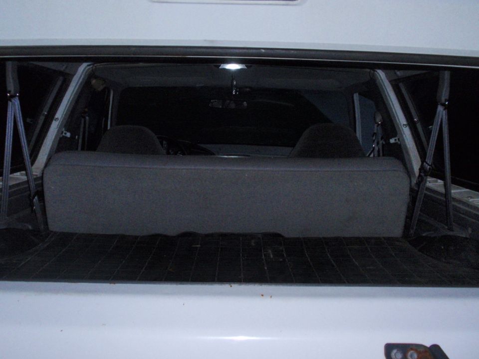 View into the back of an SUV, showing the rear seat and cargo area. Two headrests are visible behind the seat