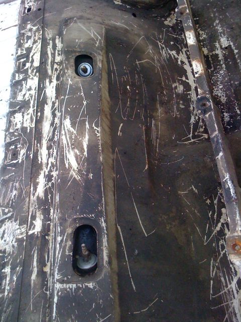 1964 Ford Ranchero - The interior of a truck bed shows two mounting points and significant scratching on the painted surface.