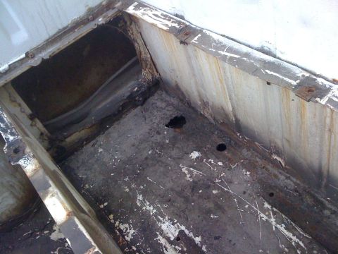 1964 Ford Ranchero - Close-up of a heavily rusted metal frame section, likely from a vehicle's undercarriage.