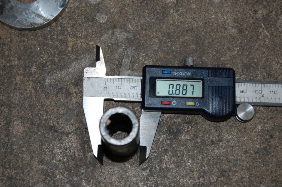 Digital caliper reads 0.887 inches while measuring a metal tube. Another metal ring is visible in the upper left