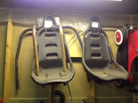 2000 Ford E350 - Two racing seats are mounted on a wall, possibly for storage or display.