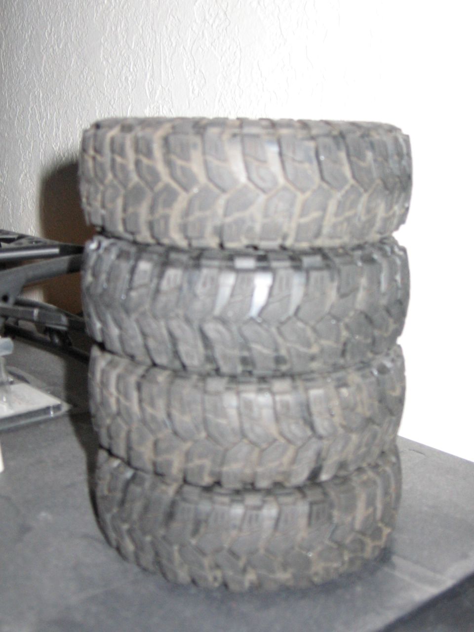 Stack of four off-road tires with aggressive tread pattern