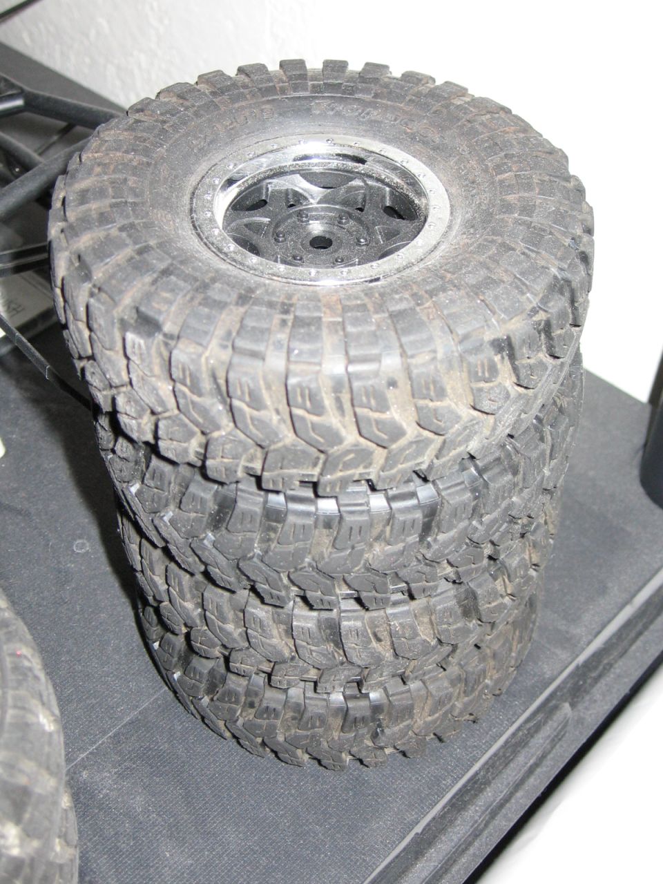 stack of four off-road tires with aggressive tread