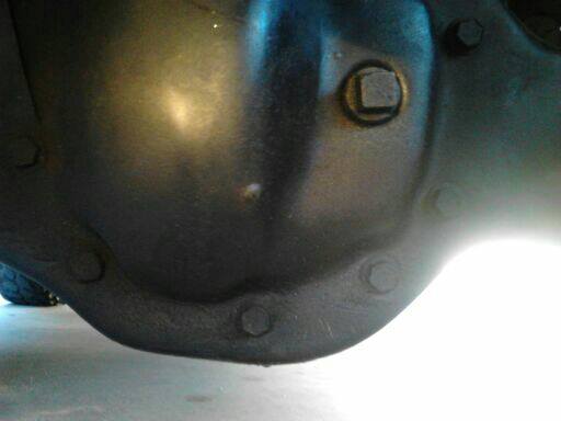 Close-up of a black rear differential housing with bolts and a fill plug