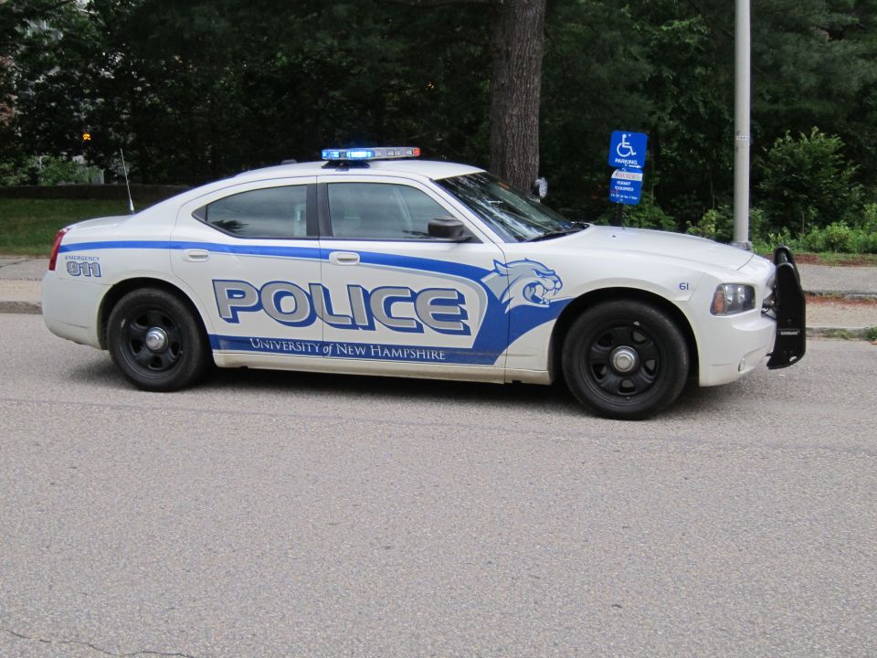White and blue University of New Hampshire Police Dodge Charger side view