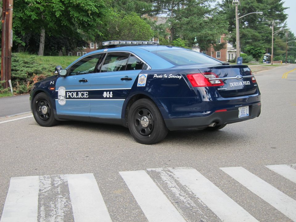 Durham Police blue Ford sedan rear three-quarter view at crosswalk