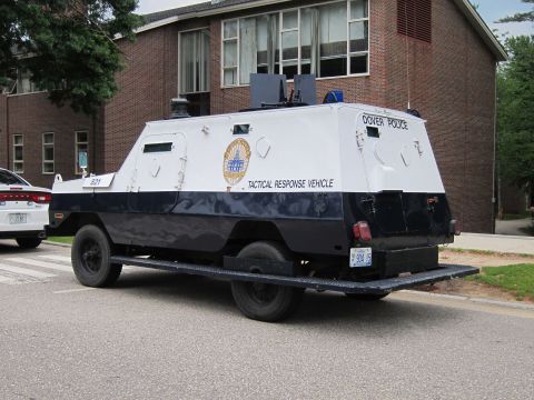 1991 Ford LTD Crown Victoria - Rear quarter view of a white-and-navy Dover Police armored truck lettered 'TACTICAL RESPONSE VEHICLE' parked by a brick building.