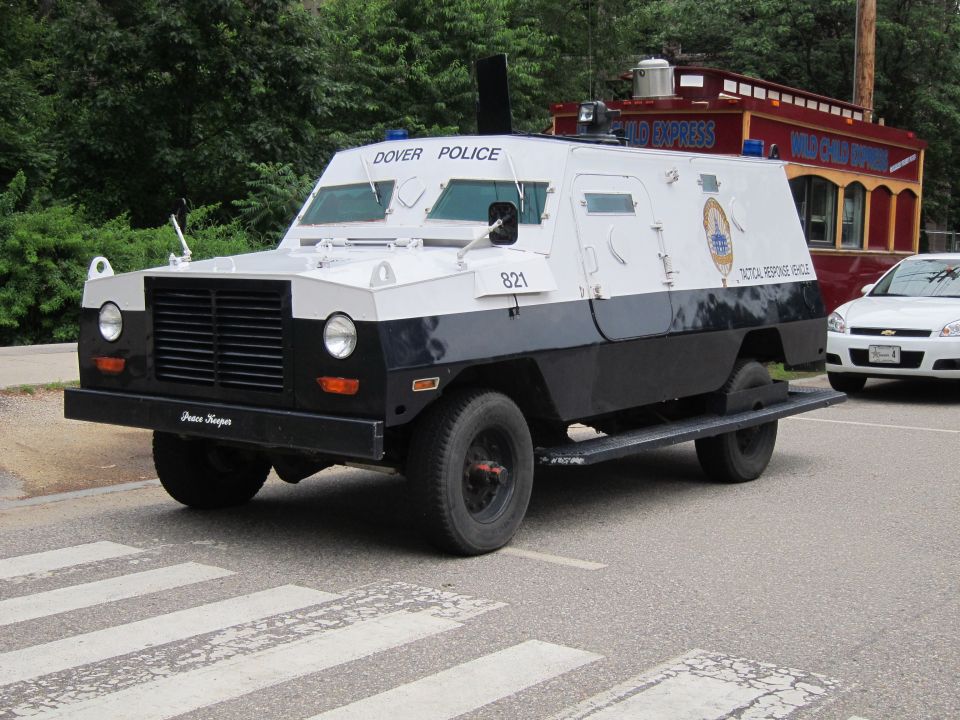 White and dark blue Dover Police armored tactical response vehicle parked at a crosswalk