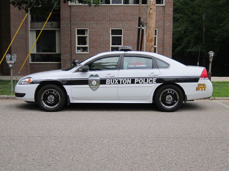 Silver and black Buxton Police Chevrolet Impala sedan, side view