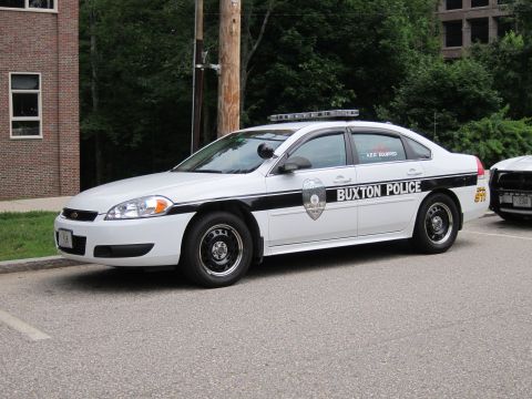 1991 Ford LTD Crown Victoria - white and black Chevrolet Impala marked 'Buxton Police' parked along a roadside beside another cruiser.