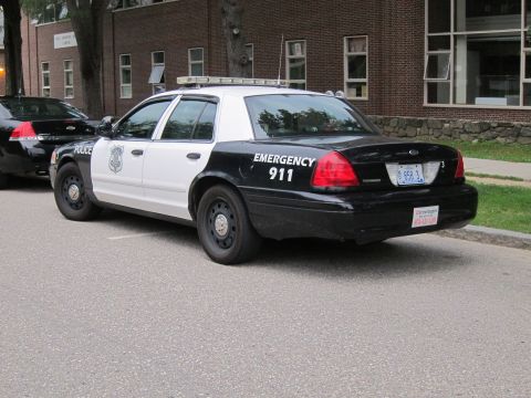 1991 Ford LTD Crown Victoria - Rear three-quarter view of a black and white Ford Crown Victoria police cruiser marked 'Emergency 911'.