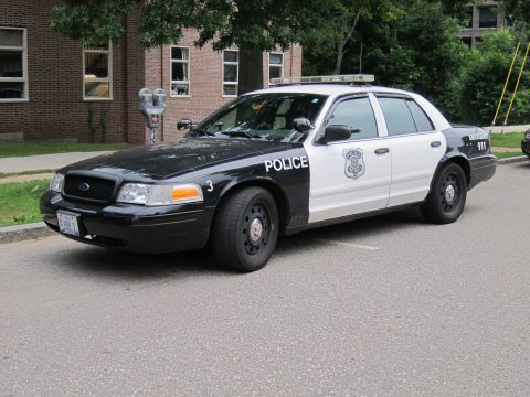 1991 Ford LTD Crown Victoria - Front three-quarter view of a black and white Ford Crown Victoria police cruiser marked 'Police' parked on a street.