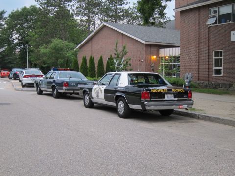 1991 Ford LTD Crown Victoria - black and white Ford LTD Crown Victoria marked 'Highway Patrol' parked at a curb ahead of other cruisers.