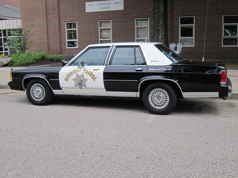 Black and white Highway Patrol Ford LTD Crown Victoria sedan, side view