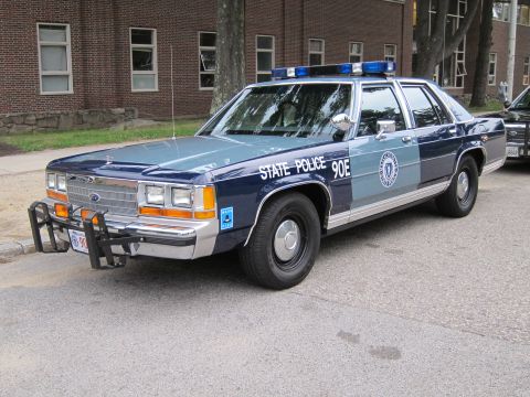 1991 Ford LTD Crown Victoria - Front three-quarter view of a two-tone blue Ford LTD Crown Victoria marked 'State Police 90E' with push bar.