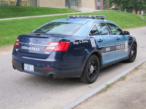 1991 Ford LTD Crown Victoria - two-tone blue Durham Police Ford sedan with Pride In Serving lettering and plate M 906 3, parked by a grassy slope.