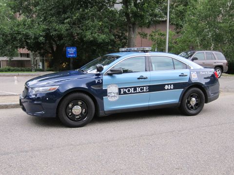 1991 Ford LTD Crown Victoria - two-tone blue Ford police sedan, unit P-3, marked Police 9-1-1 parked along a curb with an SUV behind it.