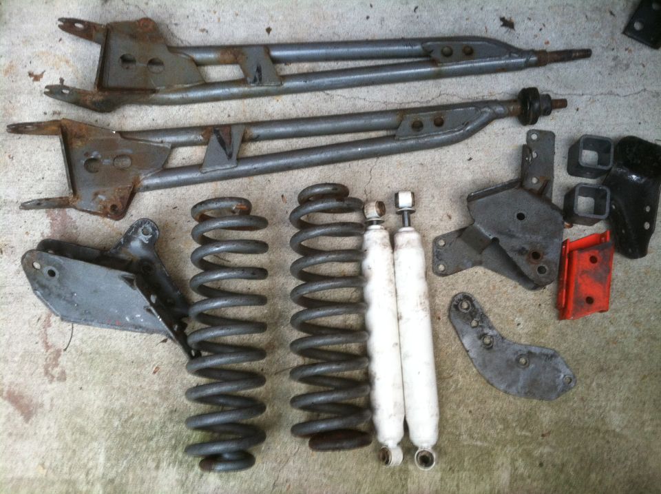 Assorted suspension parts including control arms, coil springs, and shock absorbers