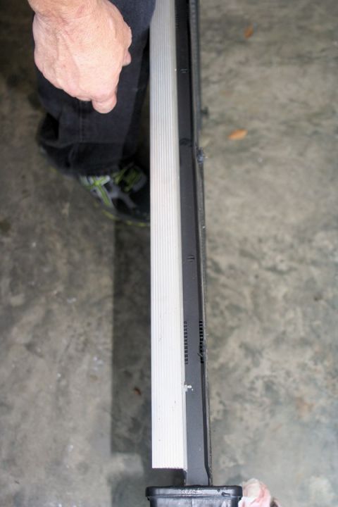 1976 Ford Ranchero - A radiator is held by a person's hand, showing its side profile.