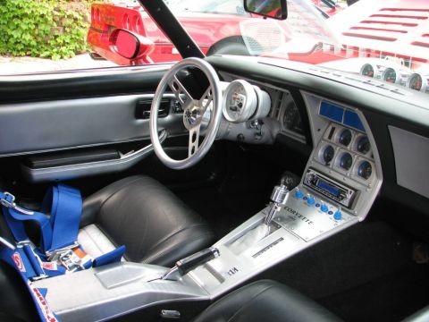 1976 Chevrolet Corvette - The interior of a modified Chevrolet Corvette features racing seats, a roll cage, and numerous aftermarket gauges.