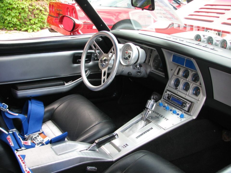 Corvette interior with racing harness, aftermarket gauges, and shifter