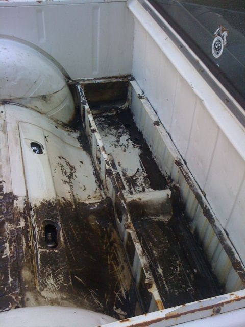 1964 Ford Ranchero - Interior of a 1964 Ford Ranchero bed, showing significant rust and dirt.