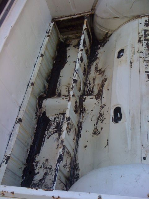 1964 Ford Ranchero - The interior of a truck bed shows significant rust and deterioration of the metal framework.