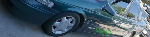 1993 Ford Taurus - A green 1993 Ford Taurus sedan is shown from a 3/4 front angle, custom green lettering on its side.