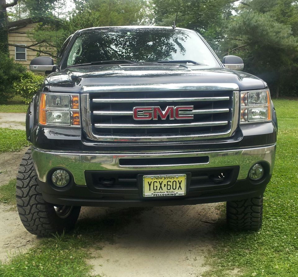 Front view of black GMC Sierra pickup truck with chrome grille and New Jersey license plate YGX-60X