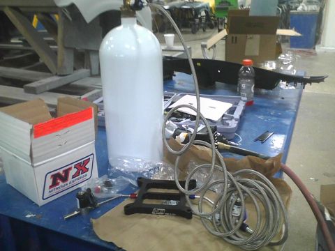 2003 Ford Crown Victoria - Nitrous oxide tank and installation kit are laid out on a workbench, ready for use.