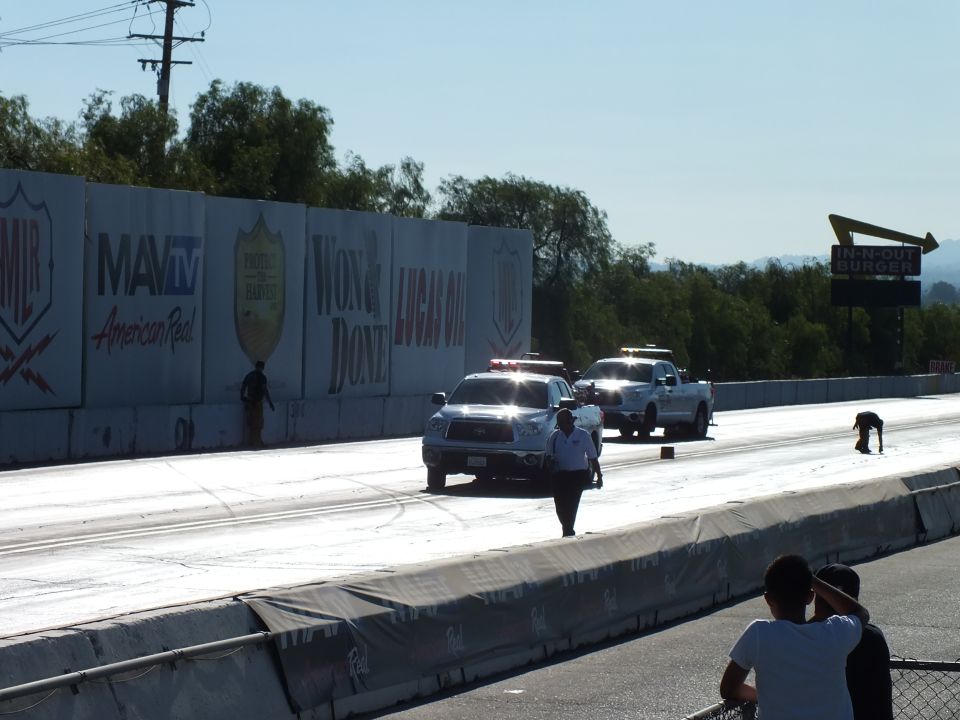 White trucks at the start of a drag strip with an official standing on track
