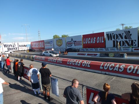 2003 Ford Crown Victoria - Cars stage on the drag strip lanes beneath Lucas Oil and Won & Done banners as spectators watch from the rail.