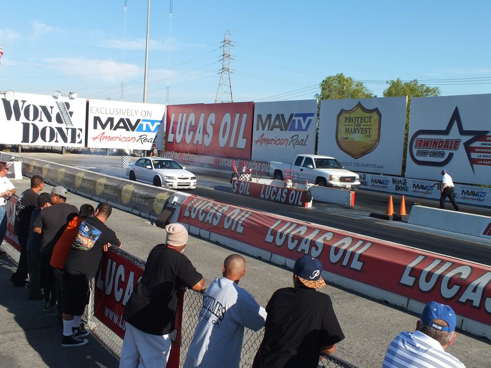 White sedan and white pickup launching down the drag strip