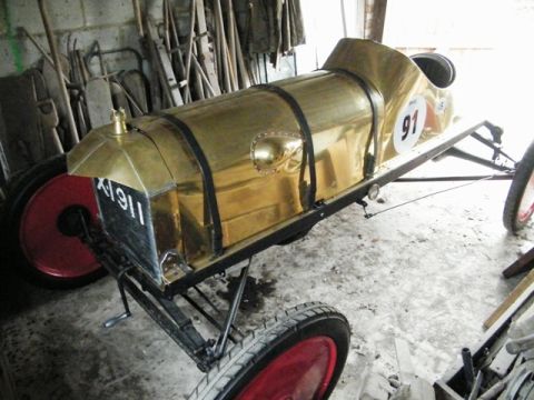 1909 Ford Model T - This brass-bodied speedster features red wheels and the number 91 on its side, but does not appear to be a 1909 Ford Model T.