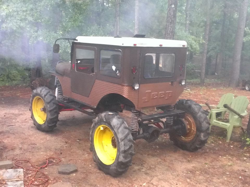 Modified Jeep with large tires and diamond plate siding, emitting smoke