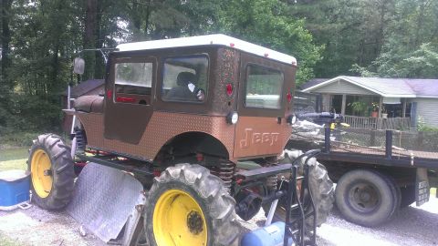 1978 Ford Bronco - This heavily modified Jeep sits on large tractor tires, suggesting a custom build rather than a stock vehicle.