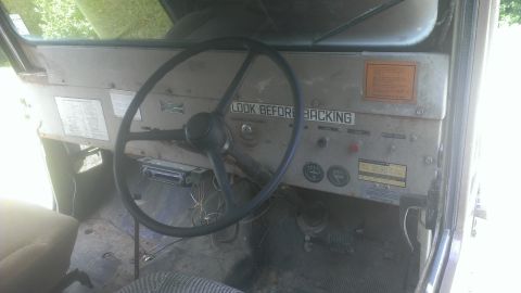 1978 Ford Bronco - The interior of a vehicle shows a dashboard with a steering wheel, gauges, and various warning labels.