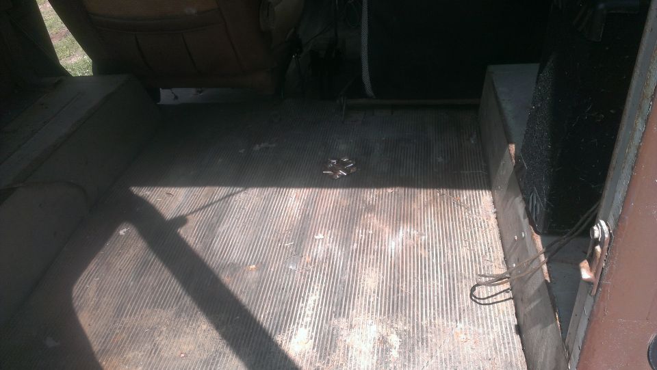 Interior cargo area with ribbed floor mat and spare tire well