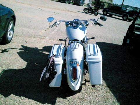1995 Ford F-150 - A white motorcycle with saddlebags is parked on a paved surface, with other vehicles visible in the background.