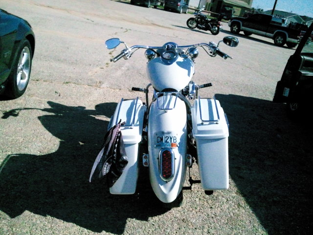 White motorcycle with saddlebags and a license plate reading CM 2YB