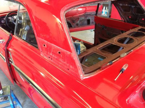 1964 Ford Fairlane - Interior view of a red 1964 Ford Fairlane undergoing restoration, showing the dashboard and door panels.