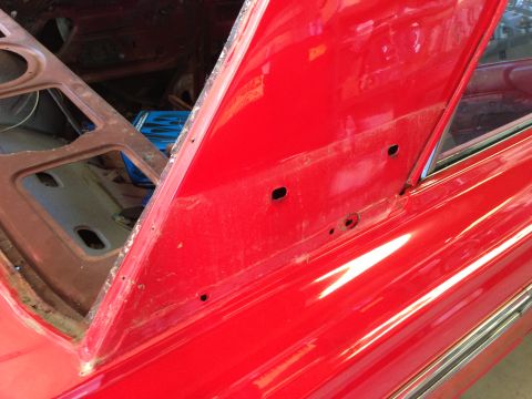 1964 Ford Fairlane - Close-up view of a red car's interior, showing the trunk area and side panel details.