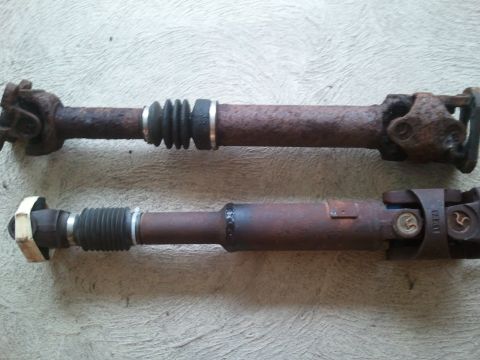 1996 Ford Bronco - Comparison of two driveshafts, showing varying degrees of rust and different protective elements.