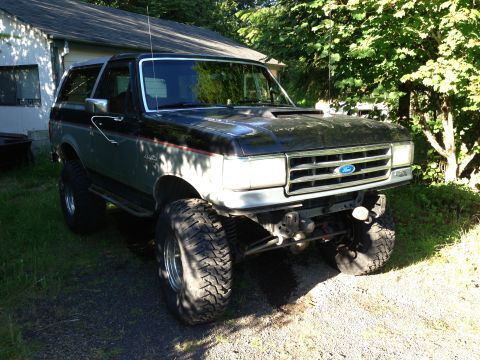 1989 Ford Bronco - This lifted Ford Bronco features a two-tone black and gray paint scheme and aggressive off-road tires.