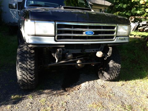1989 Ford Bronco - This lifted 1987 Ford Bronco features a chrome grille and large off-road tires.