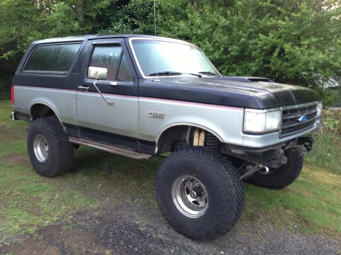 1989 Ford Bronco - This lifted 1989 Ford Bronco features a two-tone black and silver paint scheme and aggressive off-road tires.
